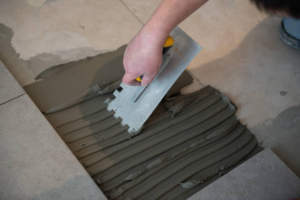 istock Tiler laying the ceramic tile on the floor. Professional worker makes renovation. Construction. Hands of the tiler. Home renovation and building new house 1311782428