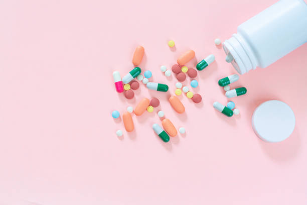 istock Multicolored tablets, pills, capsules in plastic bottle on pink background, copy space. Medicine, vitamin and nutritional supplements concept. 1311783112