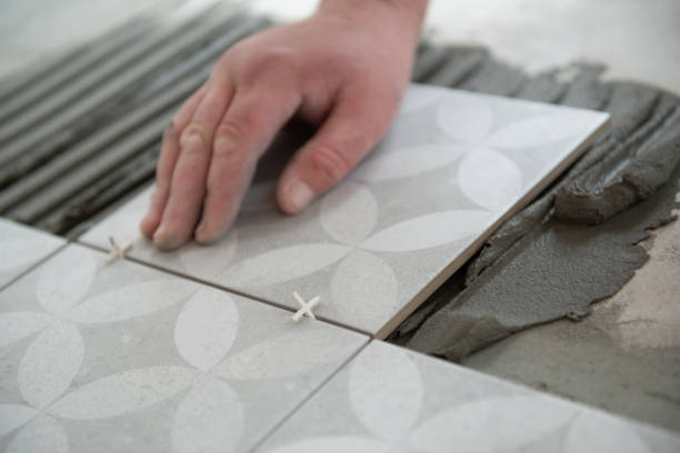 istock Tiler laying the ceramic tile on the floor. Professional worker makes renovation. Construction. Hands of the tiler. Home renovation and building new house 1311783684
