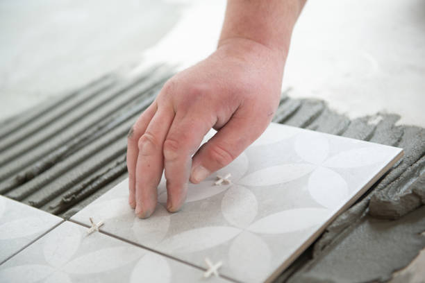 istock Tiler laying the ceramic tile on the floor. Professional worker makes renovation. Construction. Hands of the tiler. Home renovation and building new house 1311783745