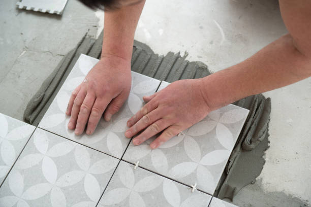 istock Tiler laying the ceramic tile on the floor. Professional worker makes renovation. Construction. Hands of the tiler. Home renovation and building new house 1311783805