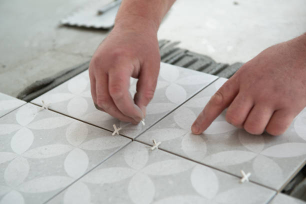 istock Tiler laying the ceramic tile on the floor. Professional worker makes renovation. Construction. Hands of the tiler. Home renovation and building new house 1311784387