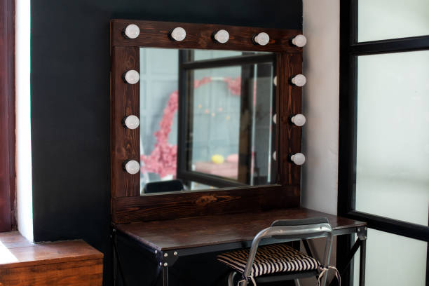 istock Modern loft interior makeup room. Table with mirror near dark wall. Dressing room with makeup mirror and table. Hairdresser place for hairdresser and make-up artist - seats and illuminated mirror. 1311786065