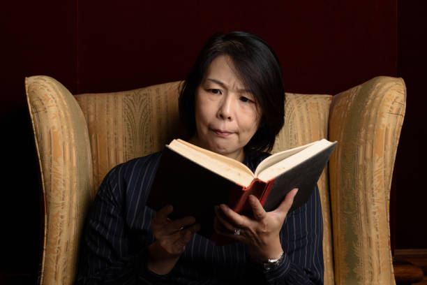 istock Woman with a troubled expression reading a book. 1311787195
