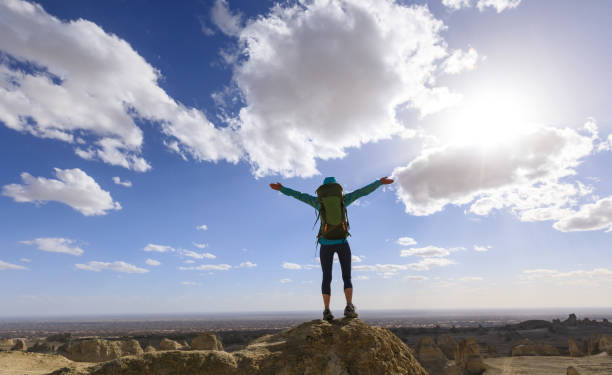 istock Successful female backpacker feel free on desert hill top 1311788218