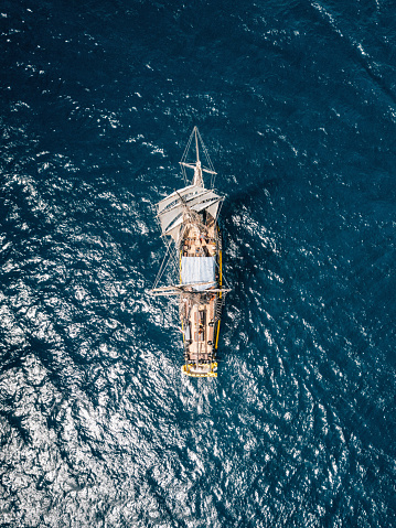Aerial view of an ancient sailing ship over blue water. Mediterranean sea.