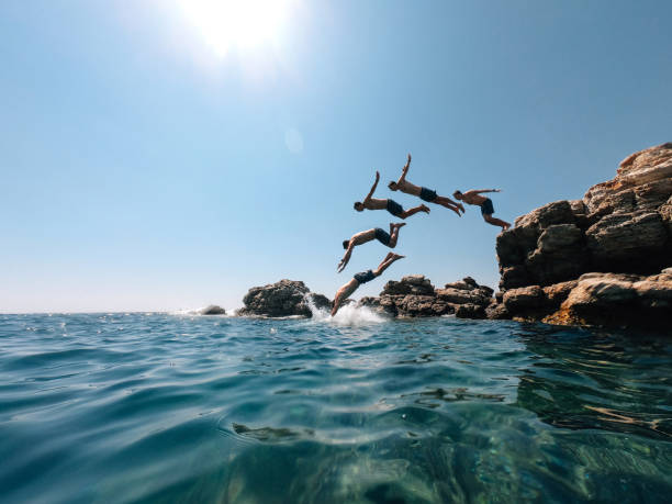 Millennial man is diving from a rock in the sea - Multiple images effect Millennial man is diving from a rock in the sea - Multiple images effect. Italy - Mediterranean sea during summer. cloning photos stock pictures, royalty-free photos & images