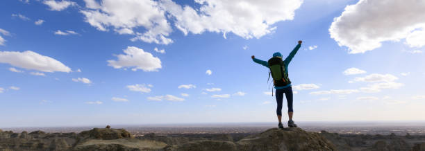 istock Successful female backpacker feel free on desert hill top 1311788633
