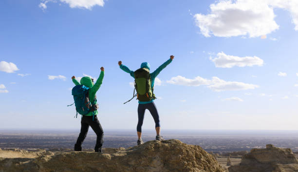 istock Two successful women backpackers hiking on sand desert 1311788662