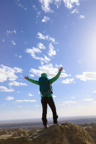 istock Successful female backpacker feel free on desert hill top 1311788755