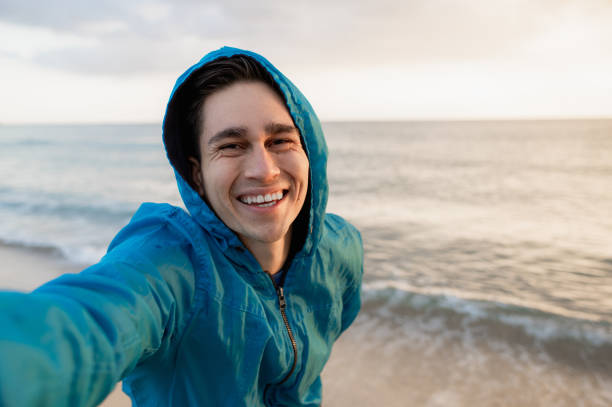istock Young happy male doing a selfie on the beach in Sardinia during sunset light. 1311789625