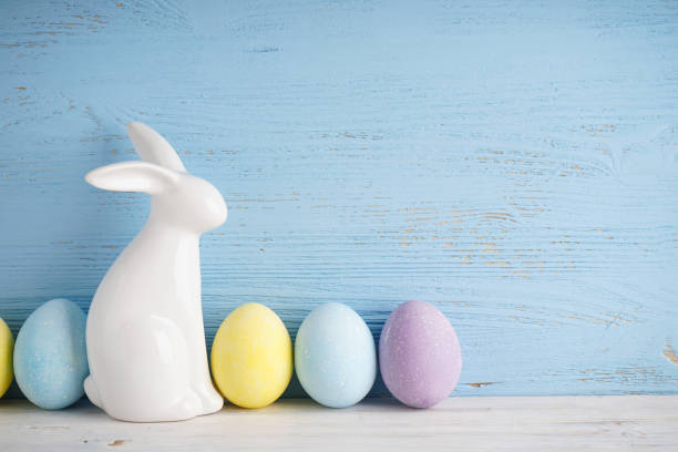 istock Easter bunny and colorful eggs on a wooden background, place for text. 1311791357