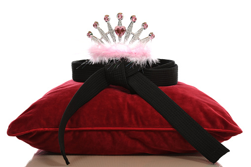Marital arts black belt with crown on a pillow.