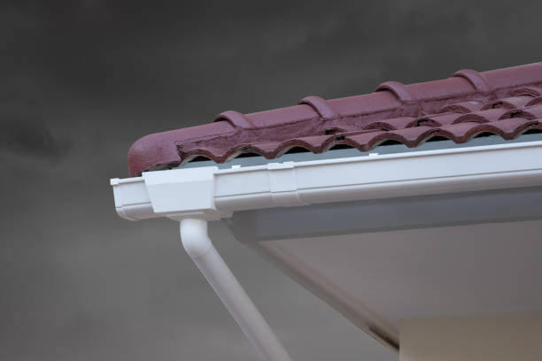 istock white plastic rain gutter of house roof. 1311792420