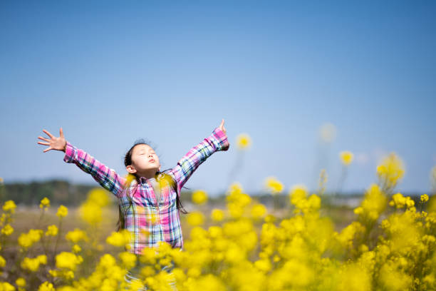 girl taking a deep breath in a flower field