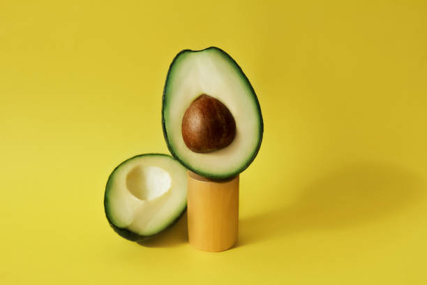 istock cut avocado fruit on celendric podium and yellow background 1311793622