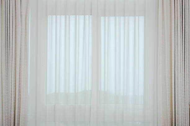istock Soft brown curtains interior decoration with morning light from the window 1311793647