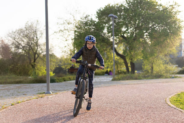 istock Young boy riding bike in park. 1311795083