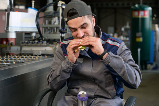 istock A young factory worker is enjoying lunch. Lunch break at work 1311796289