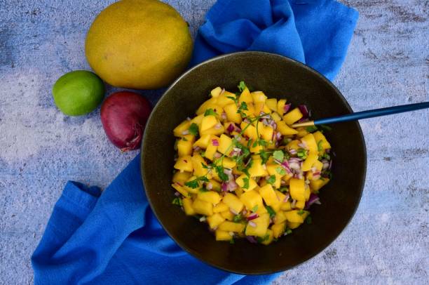 istock Fresh homemade mango salsa in a bowl on blue background 1311797597