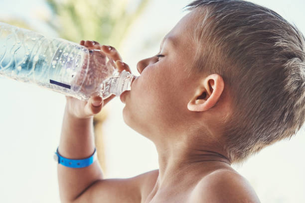 istock Slim boy with bare torso drinking bottled mineral water 1311800234