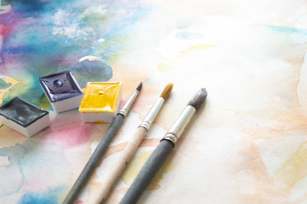 watercolor paints and brushes on a light background