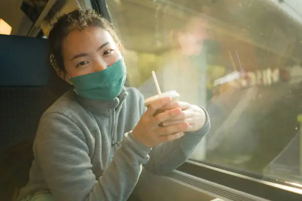 train travel during covid19 - young happy and cute Asian Japanese woman in  face mask traveling on railcar enjoying landscape through the window "n