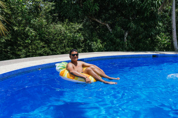 istock Man Having Fun With A Donut In The Pool 1311807649