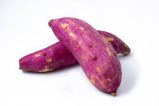 Japanese purple sweet potato root stacked and raw, on white background