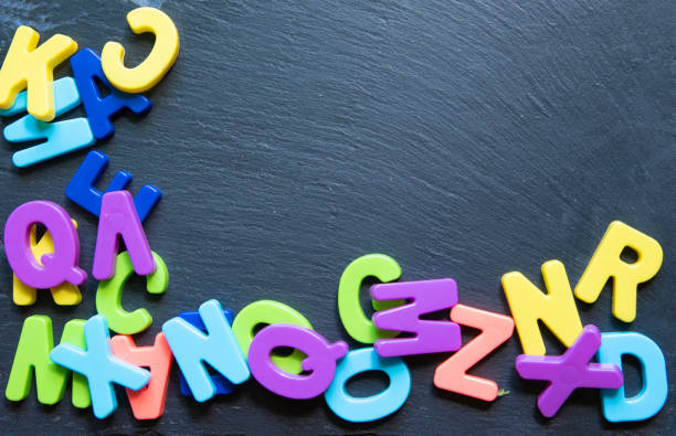 istock Frame from multicolored letters on black stone background. Topview. Copyspace. Concept back to school. 1311808906