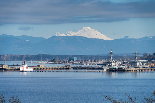 Everett WA. USA - 04-05-2021: Naval Station Everett (NAVSTA Everett) - shows Naval and Cost Gard Boats with Mt Baker in the Background