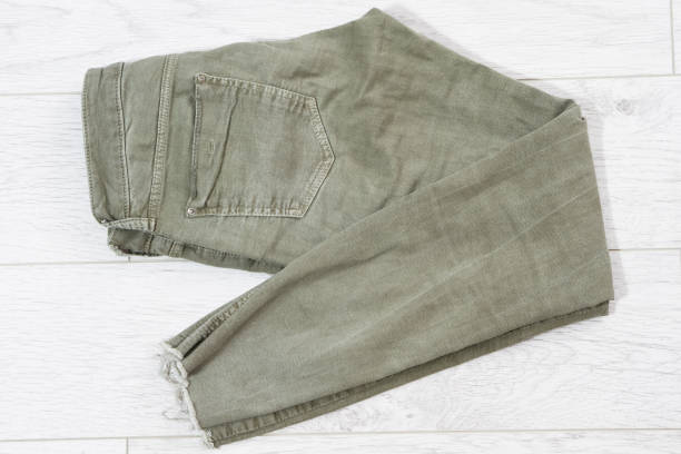 istock green folded pants on wooden table top view, khaki jeans, khaki denim 1311811942