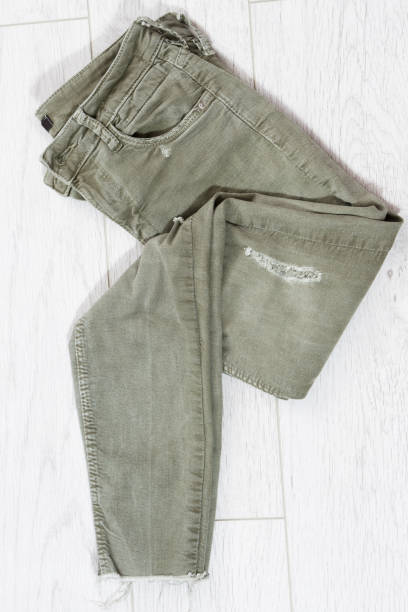 istock green folded pants on wooden table top view, khaki jeans, khaki denim 1311811943