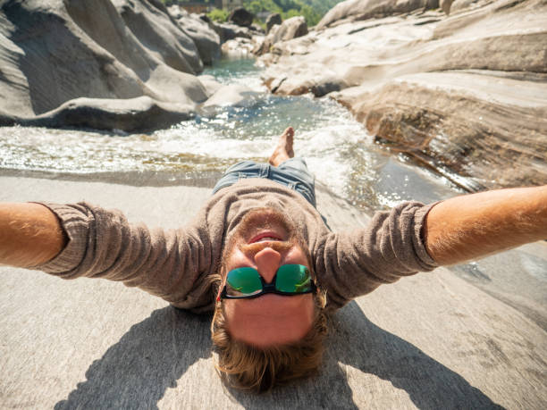 Male having fun outdoors sharing online his adventures with a selfie. Ticino canton, Switzerland