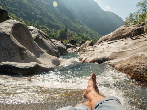istock Personal perspective of man resting by the river barefoot 1311816711