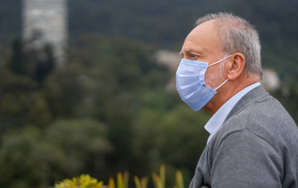 istock Senior man wearing a facemask outdoors 1311819100