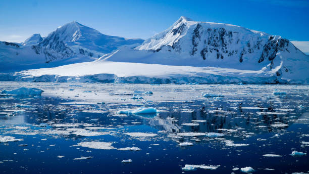 Snow covered Mountains and Icebergs in the Antarctic Peninsula on Antarctica. stock photo