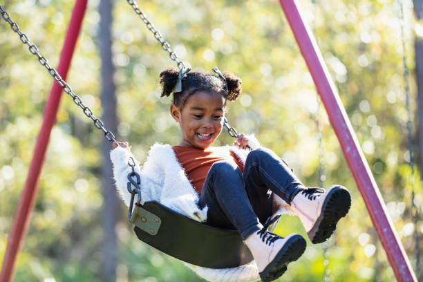 istock Little girl on playground swing 1311824580