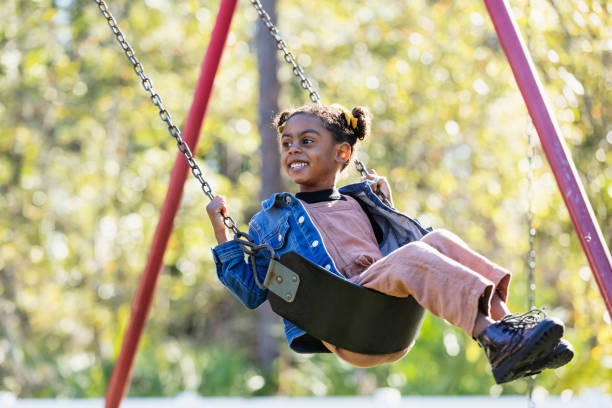 istock Little girl on playground swing 1311824667