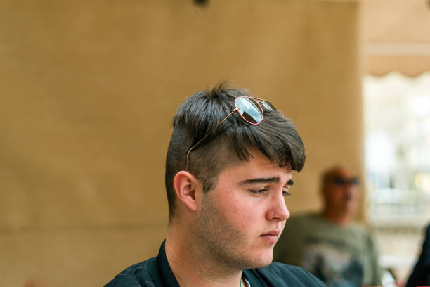 istock Young man wearing sunglasses sitting terrace bar 1311827076