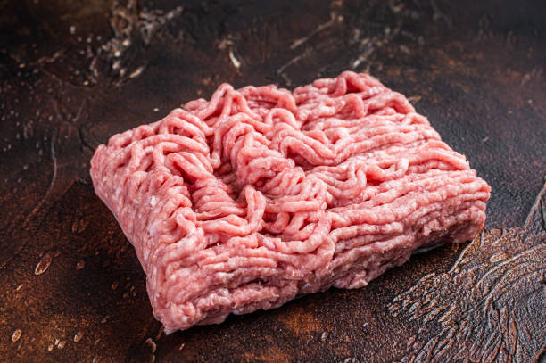istock Raw ground chicken or turkey meat on brown table. Dark background. Top View 1311829499