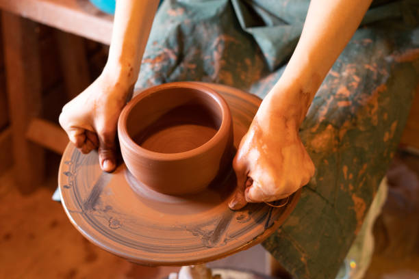 istock Potter's hands. Making clay products on a potter's wheel. Pottery master class. 1311830417