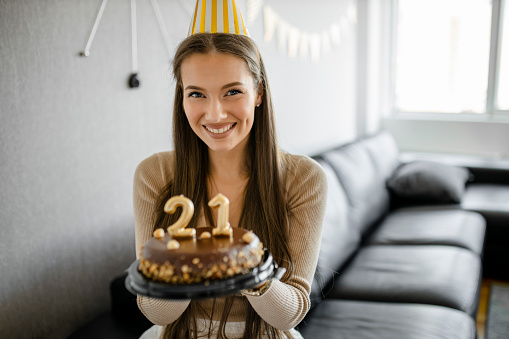 Portrait of young girl celebrating her 21st birthday at home