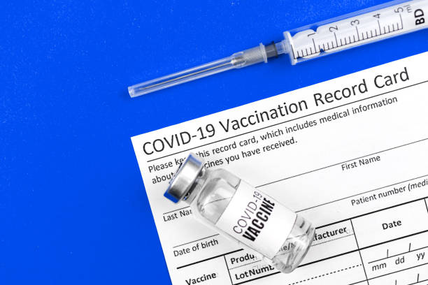 istock COVID-19 vacciation record card official document background, top view, hospital 1311832635