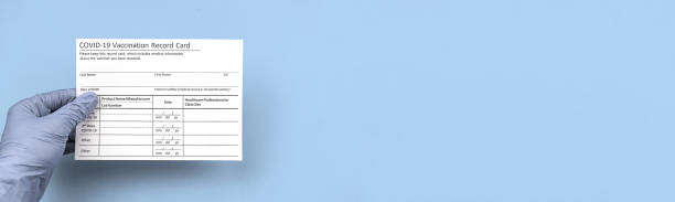 istock Doctor is holding covid vaccination record card, banner with copy space 1311832636