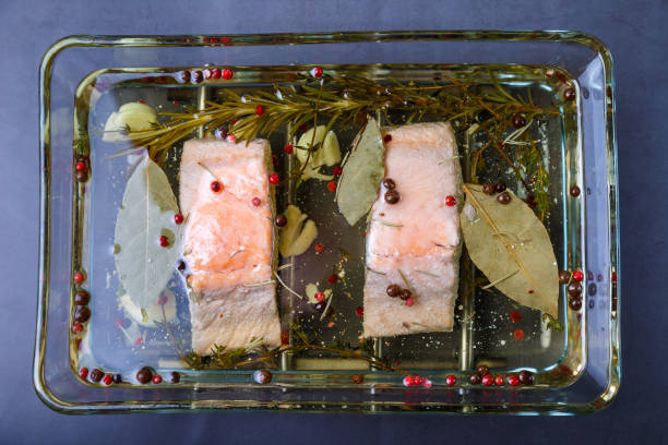 Trout (salmon) in oil with herbs and spices, cooked in a confit way. Traditional French dish. Step by step. Trout (salmon) in oil with herbs and spices, cooked by confit. A traditional French dish. Step by step. Close-up. confit stock pictures, royalty-free photos & images