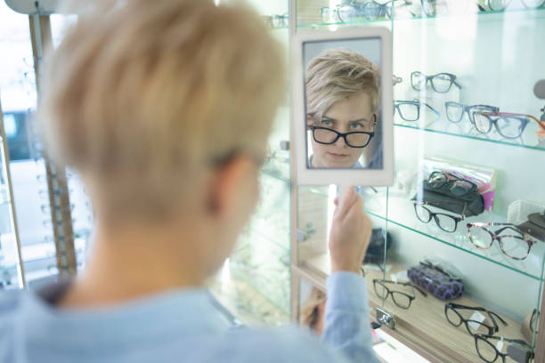 istock Attractive young woman looking at her new glasses 1311834832