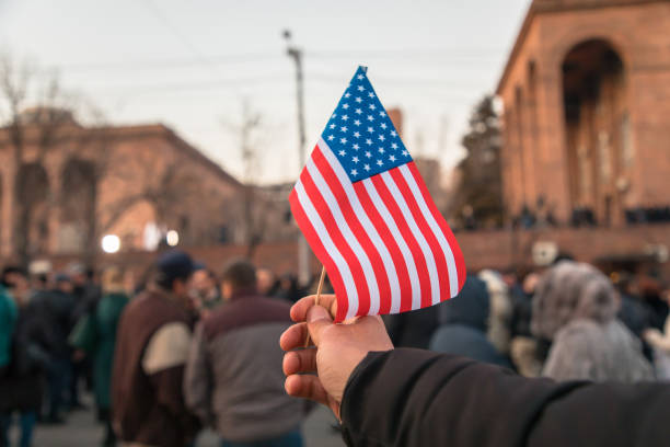 istock man holding American flag in street 1311841083