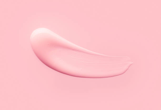 istock Glossy pink beige brown clay cream mask sample textured foundation isolated on multi-colored background 1311845255