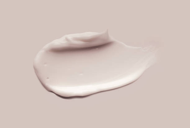 wit beige lichtgroen klei roommasker of oogcrèmesteekproef besmeurd geweven stichtingsstaal dat op veelkleurige achtergrond wordt geïsoleerd - multi vitamine stockfoto's en -beelden